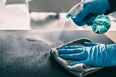 A person using Pristine Water's electrochlorination system to perform surface disinfection, ensuring a clean and sanitized environment